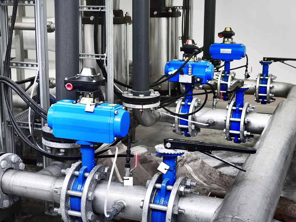 Steel metal pipes with blue pumps and valves