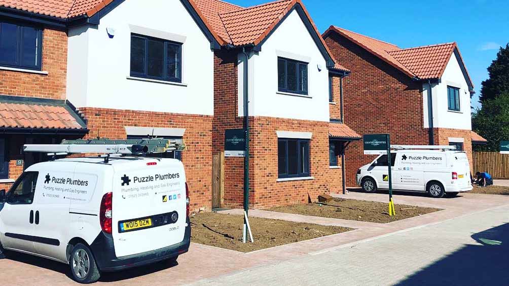 Puzzle Plumbers vans outside new builds