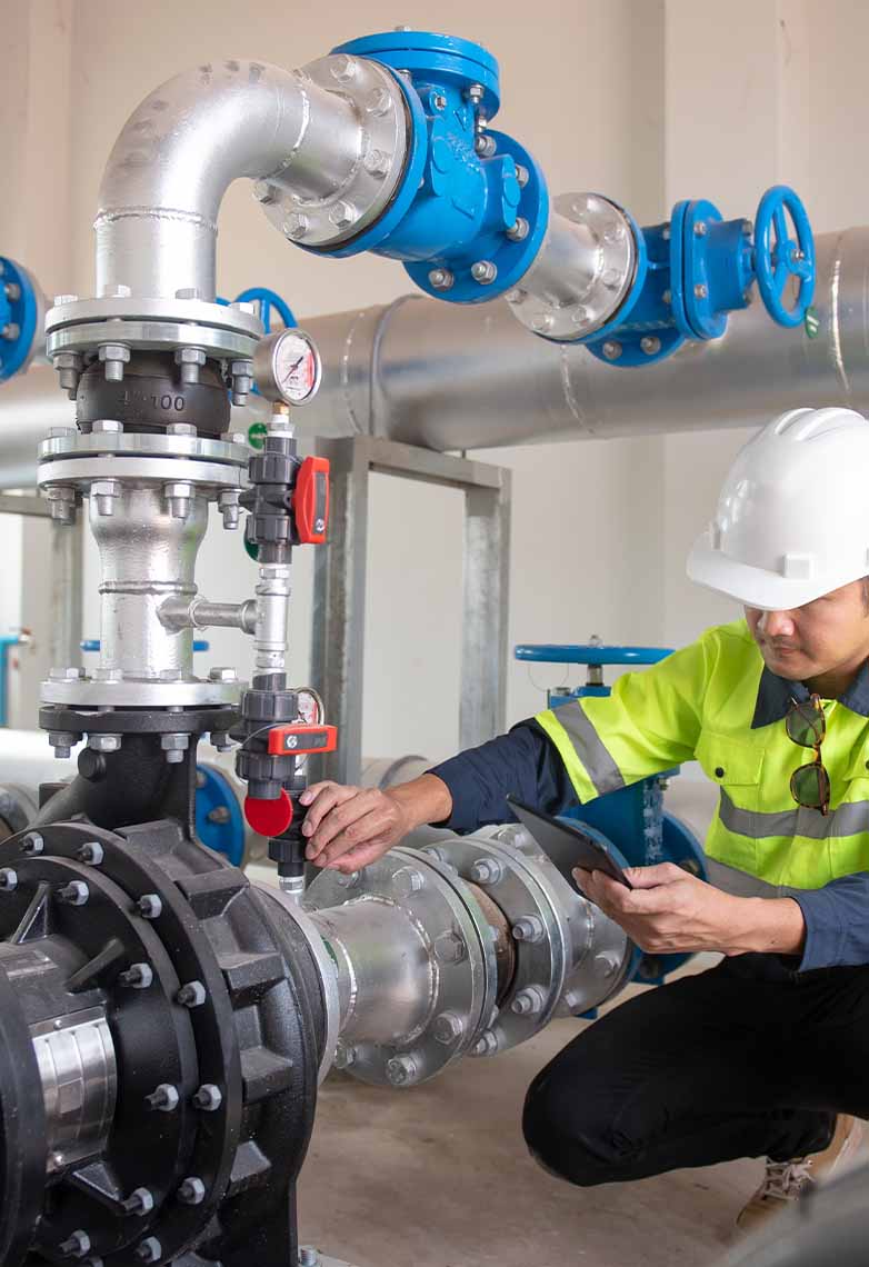 Engineer inspecting pipe connected to pump